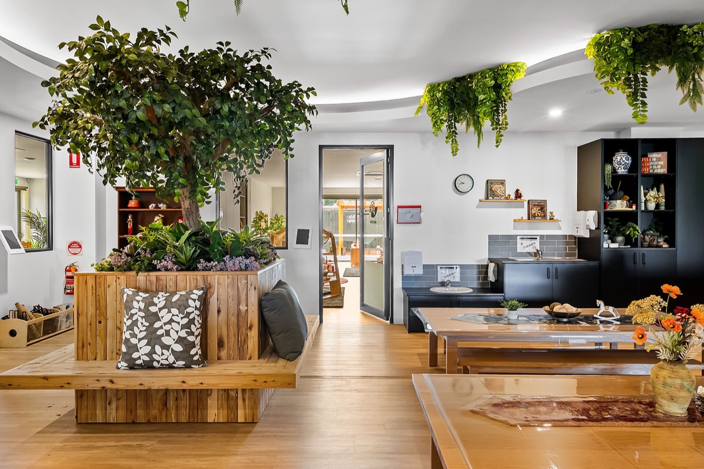 Bright play room with timber benches and planter at Treetop Early Learning, Epping